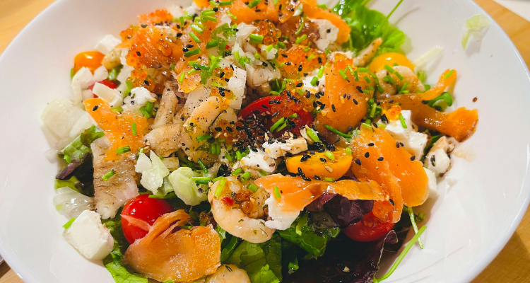 Seafood salad, complete with mandarin oranges, nestled on a large white plate